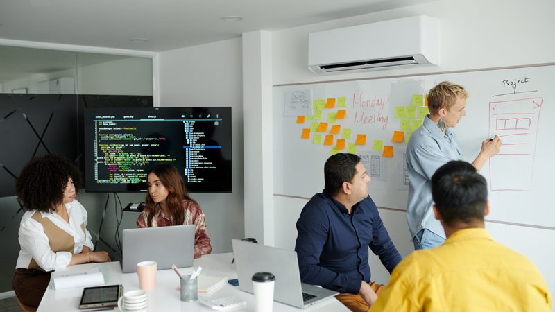 Consulting team working through a project plan at a whiteboard