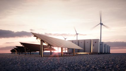 Solar panels and wind turbines at sunset